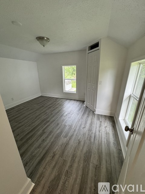 A room with wooden flooring and a window.