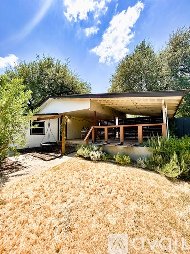 A modern house with a white exterior and a covered patio area.