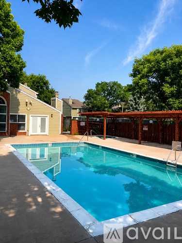A swimming pool in a backyard with a chair and a fence.