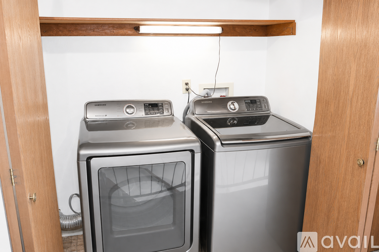 Two silver dishwashers are side by side in a kitchen.