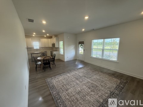 A spacious room with a dining table and chairs.