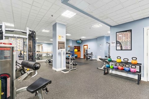 A gym with a variety of equipment including weights and machines.