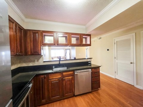 A kitchen with wooden cabinets and a black countertop.