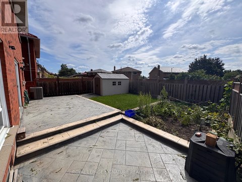 A backyard with a patio and a fence.