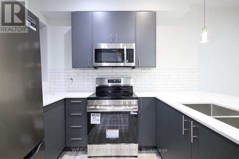 A modern kitchen with a stainless steel refrigerator and a stove top oven.