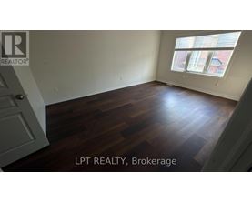 A room with wooden flooring and a window with blinds.