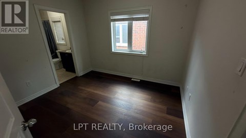 A room with a window and wooden flooring is for sale.