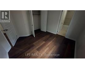 A hallway with wooden floors and white walls.