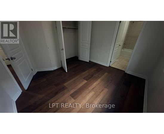 A hallway with wooden floors and white walls.