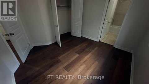 A hallway with wooden floors and white walls.