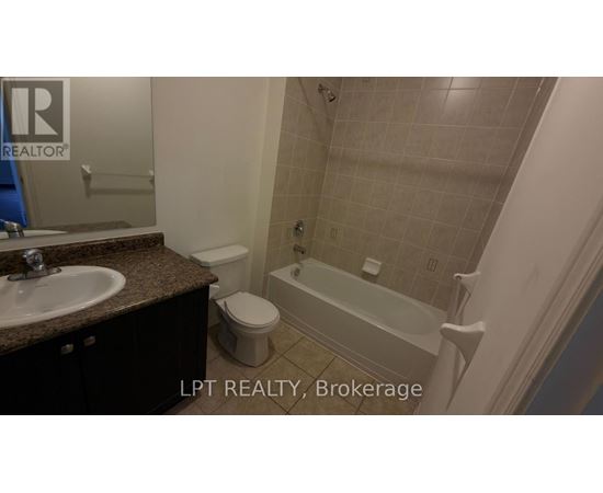 A bathroom with a toilet, sink, and bathtub.