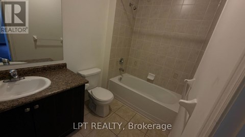 A bathroom with a toilet, sink, and bathtub.