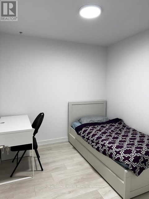 A bedroom with a bed, desk, and chair.