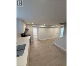 A spacious room with a staircase leading to another room.