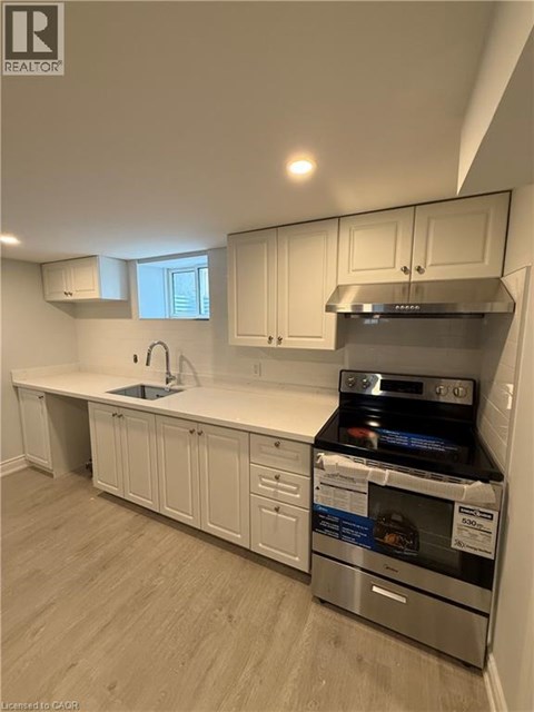 A kitchen with white cabinets and a stainless steel oven.
