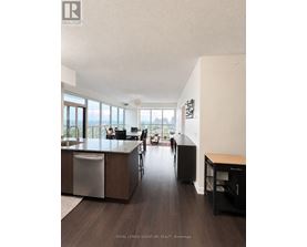 A modern kitchen with dark wood floors and a large island.