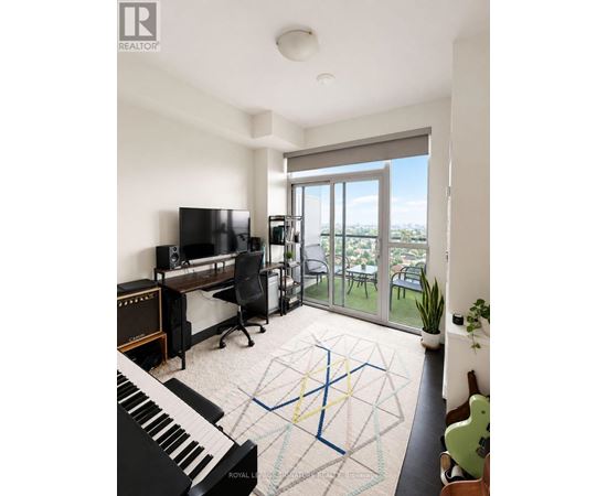 A living room with a piano, television, and sliding glass doors.