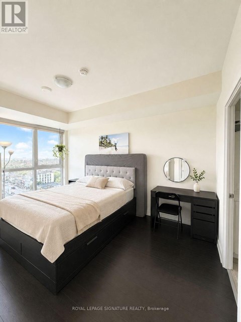 A bedroom with a large bed and a desk with a chair.