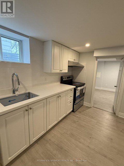 A kitchen with white cabinets and a sink.
