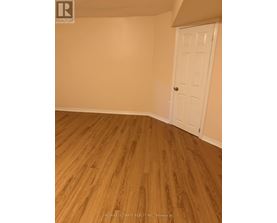 A room with a white door and wooden flooring.