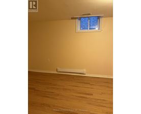 A room with a window and a radiator on the floor.
