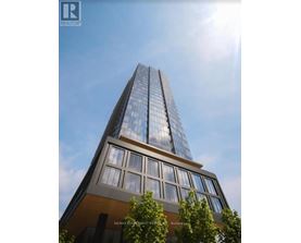 A tall building with a glass facade and a brown base is shown in the image.