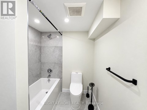 A white bathroom with a tub, toilet and sink.