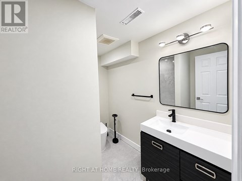 A bathroom with a sink, mirror, and toilet.