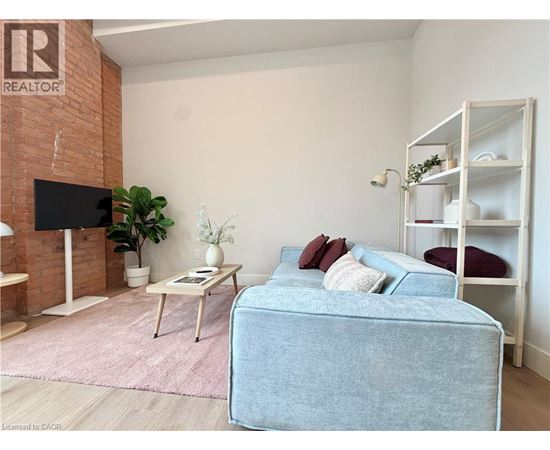 A living room with a blue couch and a white shelf.