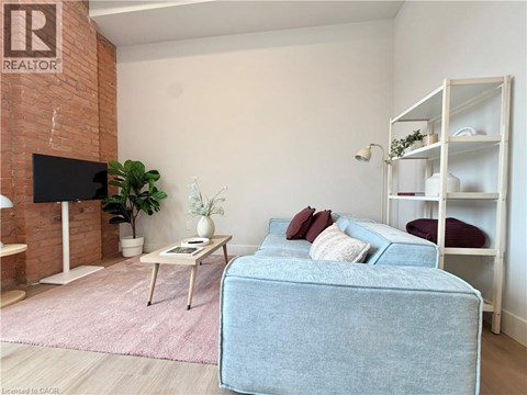 A living room with a blue couch and a white shelf.