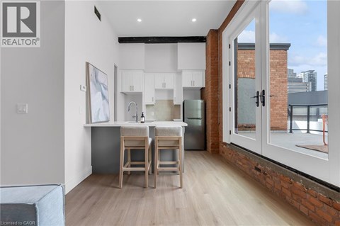 A living room with a grey sofa, a wooden coffee table, and a brick wall.