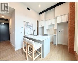 A kitchen with white cabinets and a brick wall.