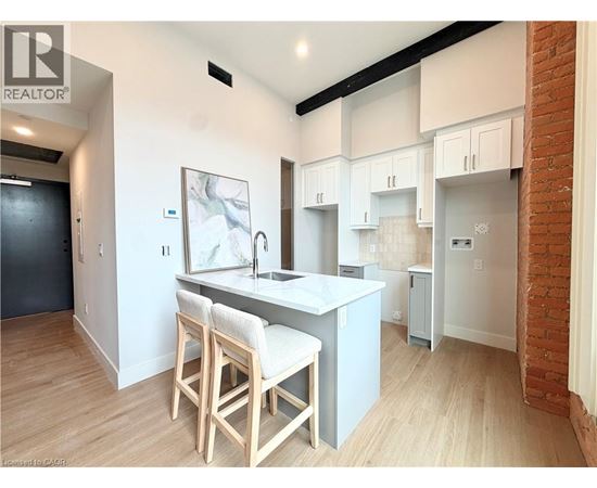 A kitchen with white cabinets and a brick wall.