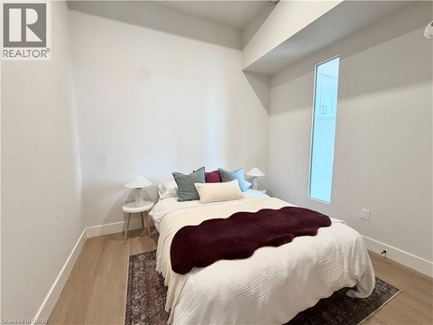 A bedroom with a large bed and a window.