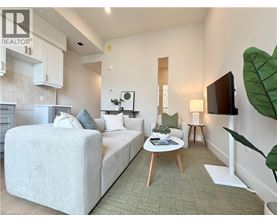 A bedroom with a large bed and a small table with a plant on it.