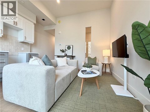 A bedroom with a large bed and a small table with a plant on it.