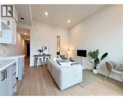 A well-lit, modern living room with a grey sofa and a wooden floor.