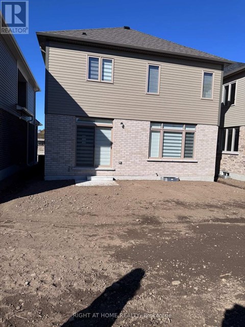 A house with a brown roof and a grey siding is shown with a blue sky in the background.
