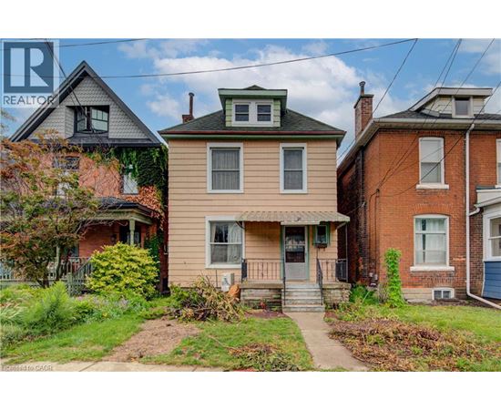 A house with a green roof is in the middle of two other houses.