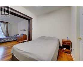 A bedroom with a bed, nightstand, and window.