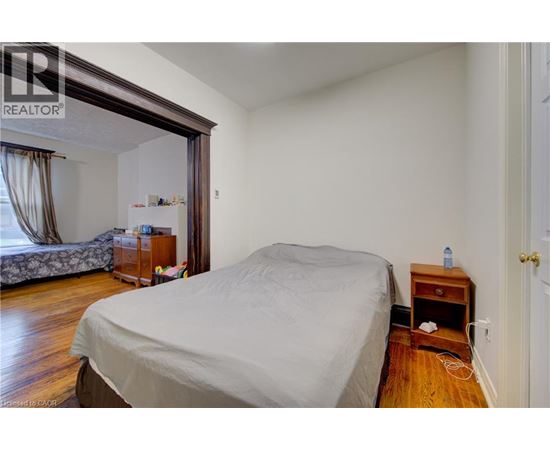 A bedroom with a bed, nightstand, and window.