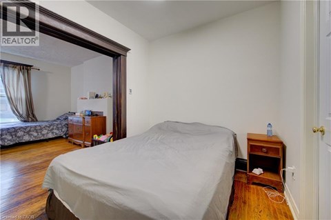 A bedroom with a bed, nightstand, and window.