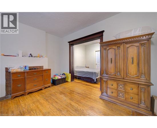 A bedroom with a large wooden armoire and a dresser.