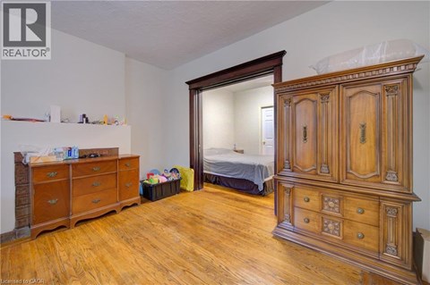 A bedroom with a large wooden armoire and a dresser.