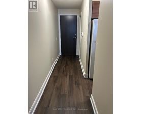 A hallway with a dark blue door and wooden flooring.