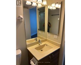 A bathroom with a sink, mirror and toilet.