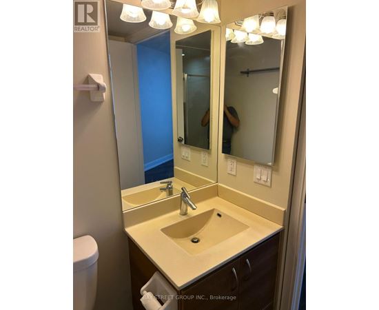 A bathroom with a sink, mirror and toilet.