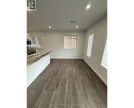 A room with a wooden floor and a window with blinds.