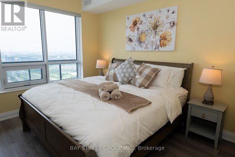 A bedroom with a large bed and a view of the city.
