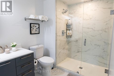 A white toilet sits next to a white sink in a bathroom.